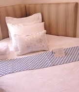 bed with white linens blue polka dot throw