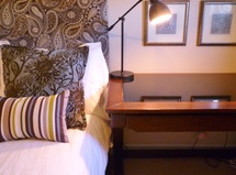 bed next to desk with lamp